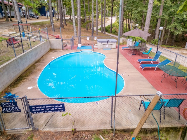 community pool featuring a patio and fence