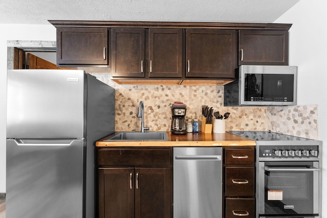 kitchen with a sink, dark brown cabinetry, decorative backsplash, and stainless steel appliances