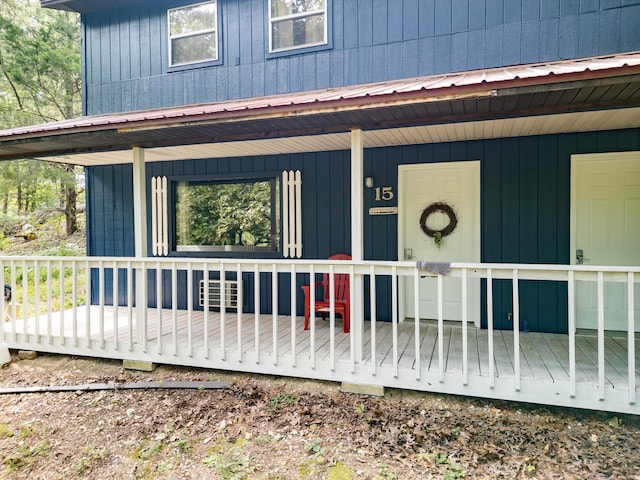 entrance to property with covered porch and metal roof