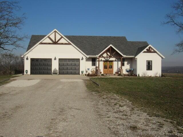 modern inspired farmhouse featuring a front yard, a garage, and dirt driveway