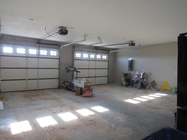 garage with electric panel and a garage door opener