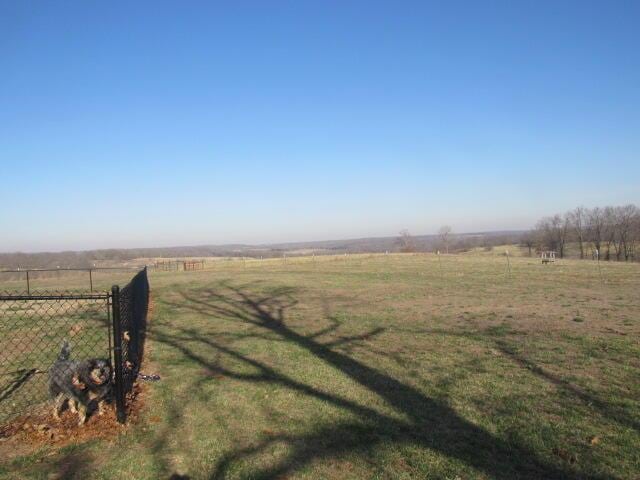 view of yard with a rural view and fence