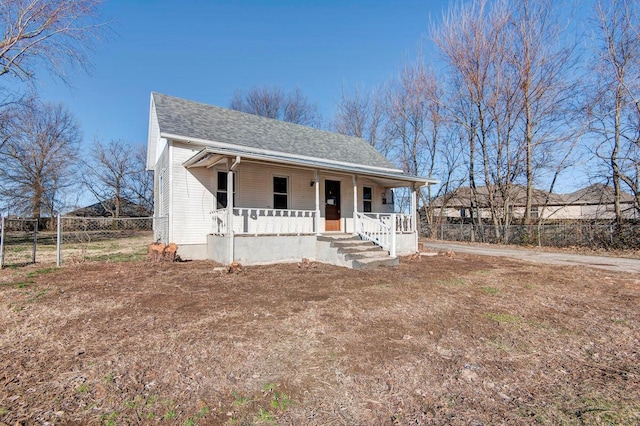 view of front of home featuring a porch, fence, and a shingled roof