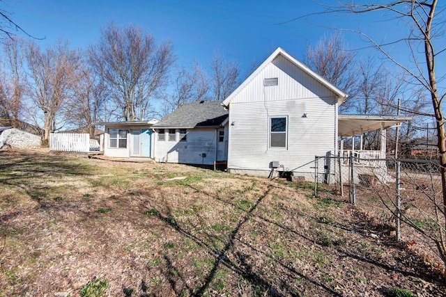 rear view of property with a carport and fence