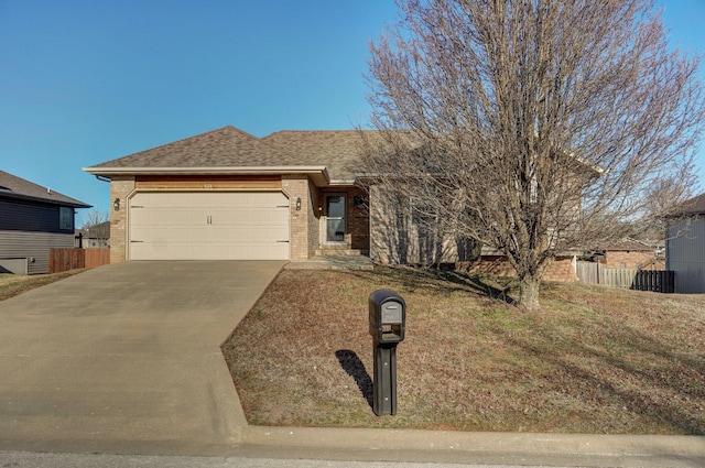 single story home with driveway, fence, a shingled roof, a garage, and brick siding