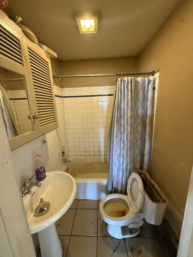 bathroom featuring tile patterned floors, visible vents, toilet, a sink, and backsplash