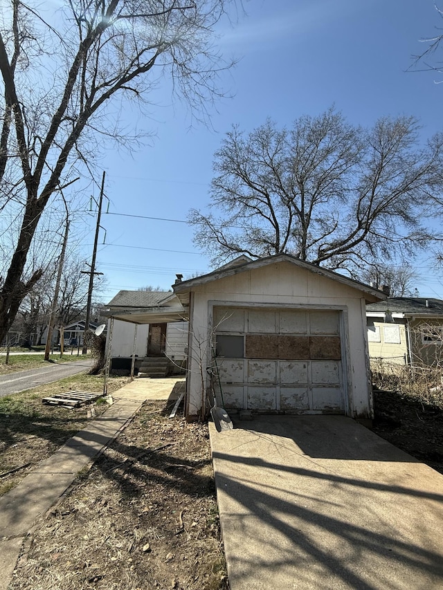 view of front of property with driveway, a detached garage, and an outdoor structure