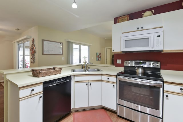 kitchen featuring white microwave, stainless steel electric range oven, black dishwasher, a peninsula, and a sink