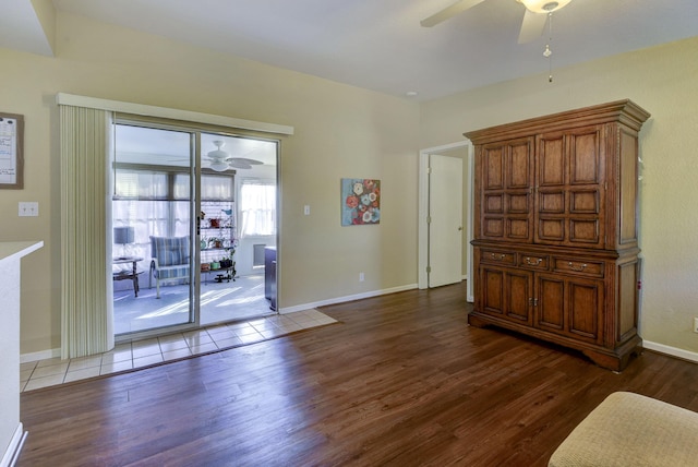 interior space featuring baseboards, wood finished floors, and a ceiling fan