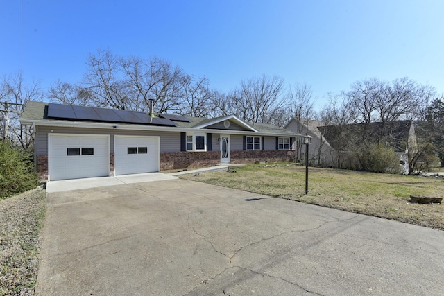 ranch-style house with a front yard, driveway, a garage, brick siding, and roof mounted solar panels