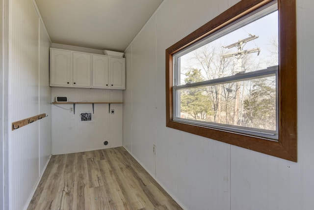 laundry room with cabinet space, hookup for an electric dryer, and light wood-style floors