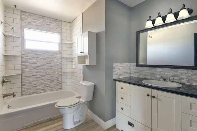 full bathroom featuring toilet, wood finished floors, washtub / shower combination, decorative backsplash, and baseboards