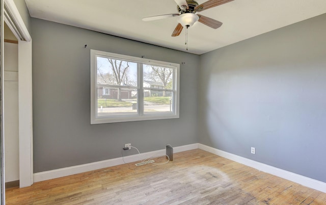 spare room featuring ceiling fan, baseboards, and wood finished floors