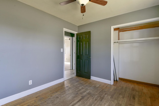 unfurnished bedroom featuring a closet, baseboards, and wood finished floors