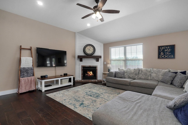 living area featuring a ceiling fan, baseboards, lofted ceiling, a fireplace, and dark wood-type flooring