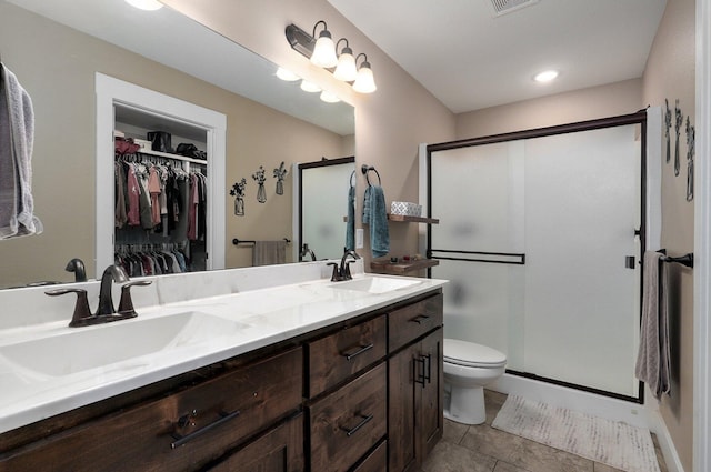 full bath with double vanity, toilet, a stall shower, and a sink