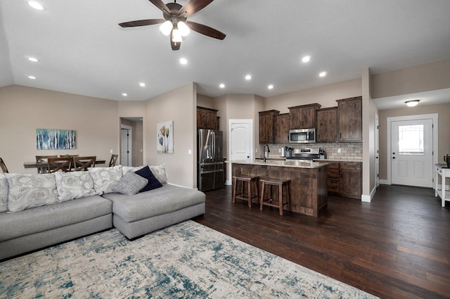 living area with a ceiling fan, baseboards, recessed lighting, dark wood-style flooring, and vaulted ceiling