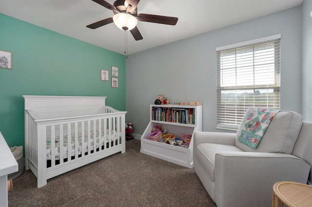 bedroom featuring a crib, a ceiling fan, and carpet floors