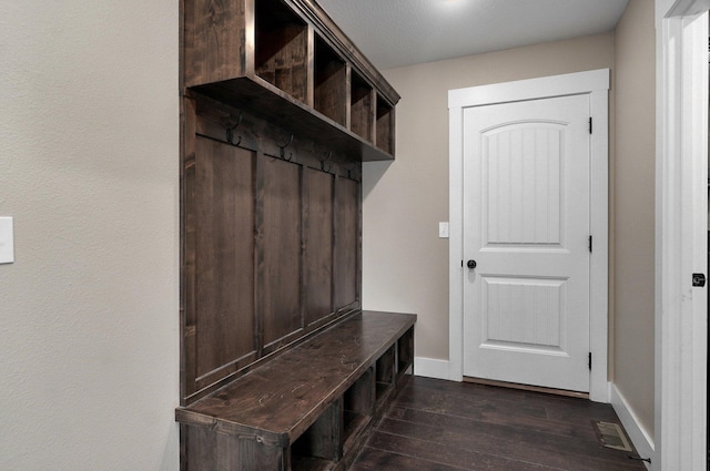 mudroom with visible vents, baseboards, and dark wood finished floors