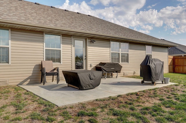 rear view of property with a patio area, a lawn, roof with shingles, and fence