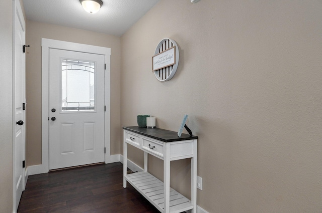 foyer featuring baseboards and dark wood-style flooring