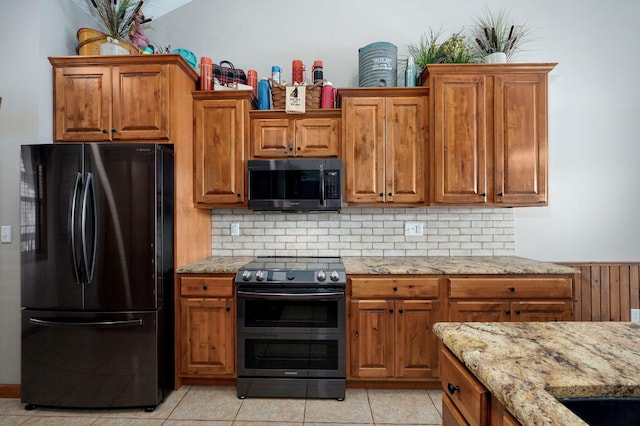 kitchen featuring brown cabinets and black appliances