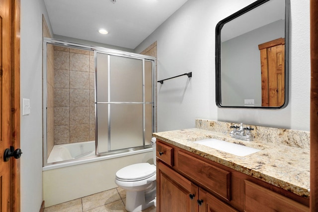 bathroom featuring tile patterned flooring, toilet, vanity, and enclosed tub / shower combo