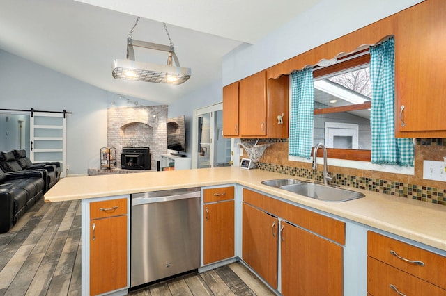 kitchen with open floor plan, dishwasher, a barn door, and a sink