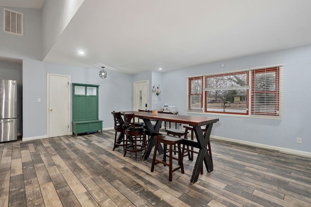 dining room with dark wood finished floors, visible vents, and baseboards