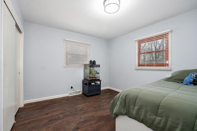 bedroom featuring visible vents, baseboards, dark wood-style flooring, and a closet