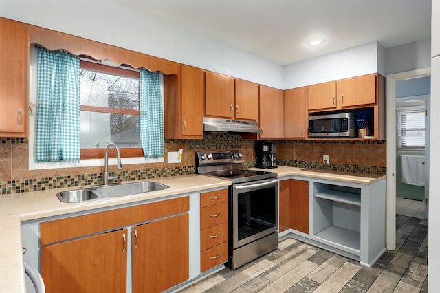 kitchen with under cabinet range hood, stainless steel appliances, light countertops, and a sink