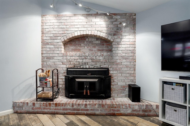 room details with a brick fireplace and wood finished floors