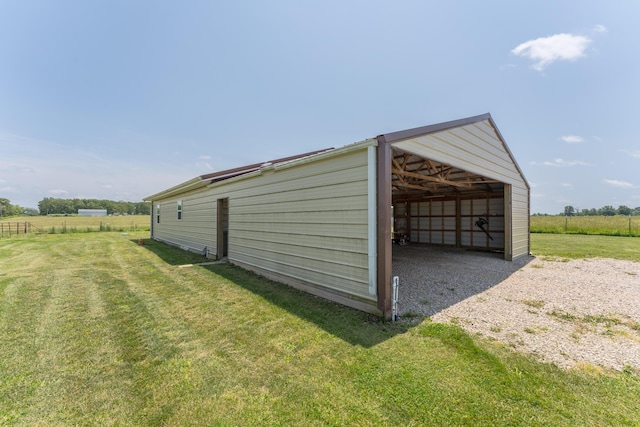 view of pole building featuring a carport, a rural view, gravel driveway, and a yard