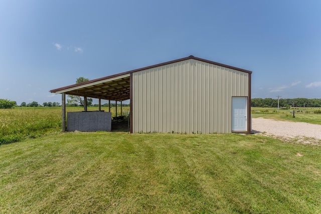 view of pole building featuring a yard, a rural view, and driveway