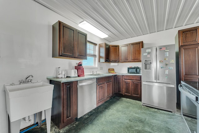 kitchen with a sink, stainless steel appliances, concrete floors, and light countertops