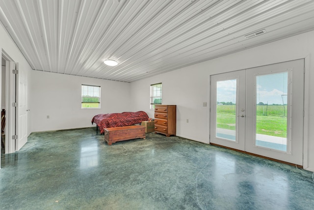 unfurnished bedroom featuring access to exterior, visible vents, multiple windows, and french doors