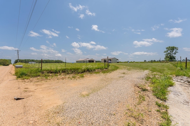 view of road with a rural view and gravel driveway