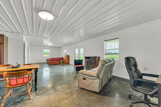 living area featuring baseboards, a wealth of natural light, and finished concrete floors