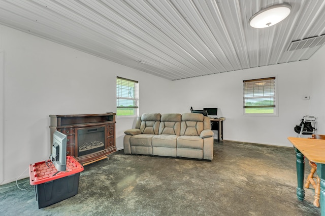 living room with baseboards, visible vents, and concrete flooring