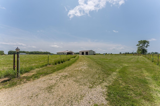 view of road featuring a pole building, a rural view, and driveway