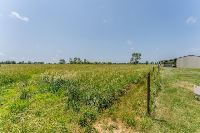 exterior space with a rural view, an outdoor structure, and a pole building