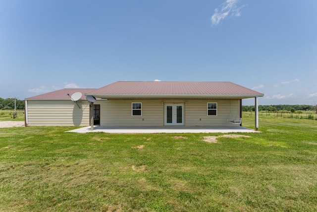 back of house featuring french doors, a patio, a lawn, and metal roof