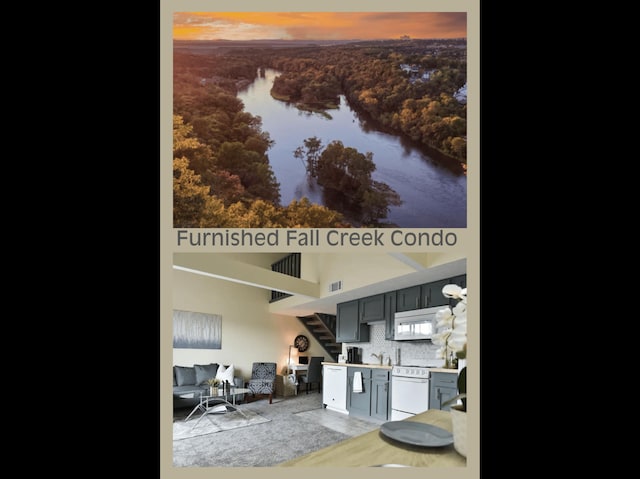 interior space with white appliances, visible vents, a sink, decorative backsplash, and a water view