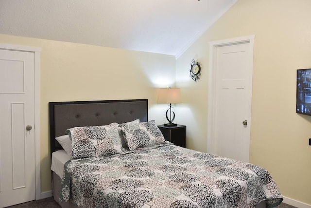 bedroom featuring baseboards, carpet floors, crown molding, and vaulted ceiling