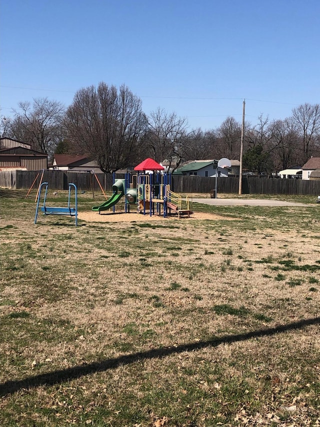 community jungle gym with a yard and fence