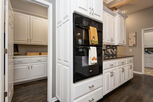 kitchen with decorative backsplash, dark wood-style flooring, white cabinetry, and dobule oven black