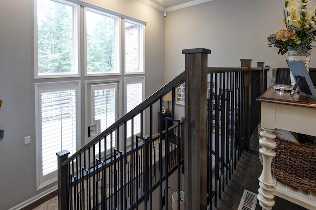 staircase featuring crown molding, a high ceiling, and a healthy amount of sunlight