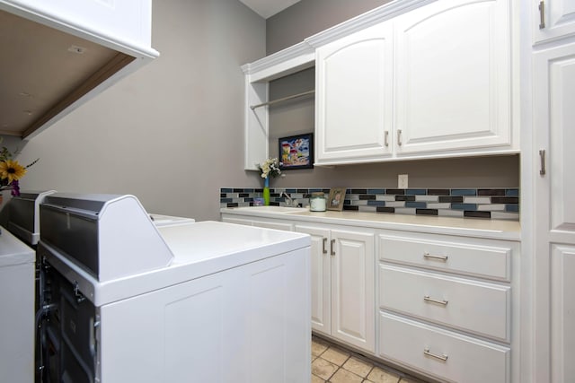 laundry area with washer and dryer, cabinet space, and light tile patterned floors