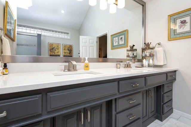 full bathroom with double vanity, lofted ceiling, and a sink