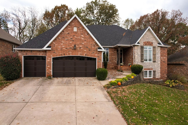 traditional home with a garage, brick siding, stone siding, and driveway